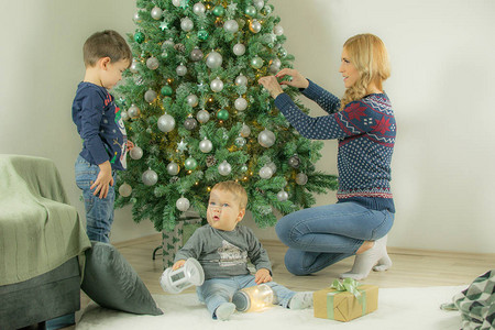 母亲和大儿子在小儿子用在地板上玩时图片