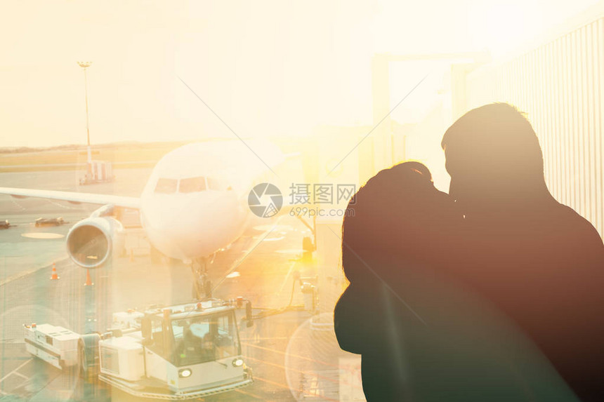 在机场背景上亲吻一对情侣约两个人在飞机附近相遇图片