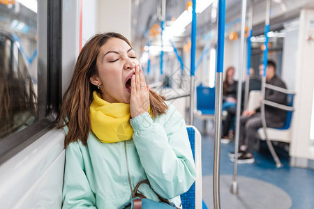 失眠女孩在下班回家后在地铁里睡觉或午睡图片