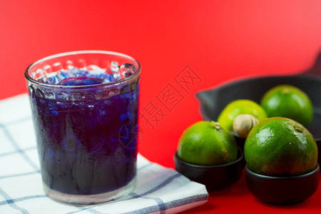 蝴蝶豌豆汁与红色背景中的柠檬汁混合背景图片
