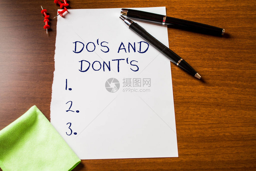 显示DoS和Dont的文字标志商业照片展示有关某些活动或行为的规则或习俗空白文具木桌钢笔图片