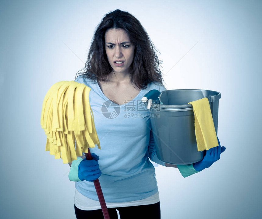 年轻漂亮的心烦意乱的家庭主妇拿着桶拖把清洁喷雾图片