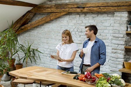 可爱快乐的年轻夫妇一起做饭在生锈厨房玩得开心图片
