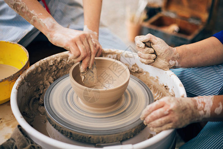 成人和儿童的手制作陶器图片