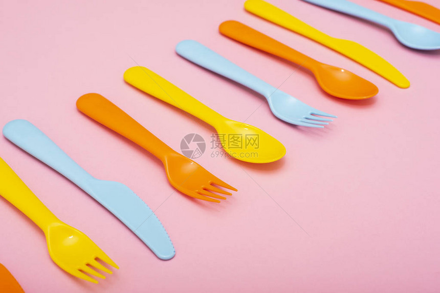 彩色塑料餐具粉红色背景的叉子刀图片