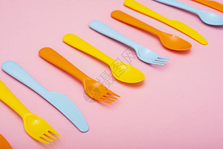 彩色塑料餐具粉红色背景的叉子刀图片