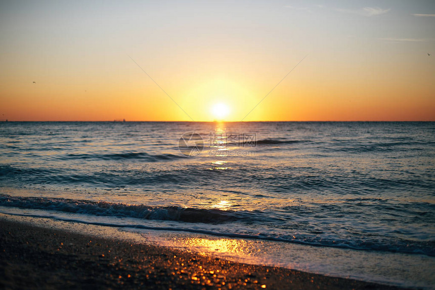 美丽的太阳升起和海浪泡沫特写在沙滩与贝壳热带岛屿夕阳下的海浪宁静的平静时刻暑图片
