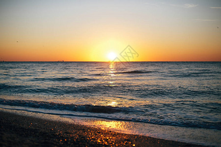 美丽的太阳升起和海浪泡沫特写在沙滩与贝壳热带岛屿夕阳下的海浪宁静的平静时刻暑背景图片