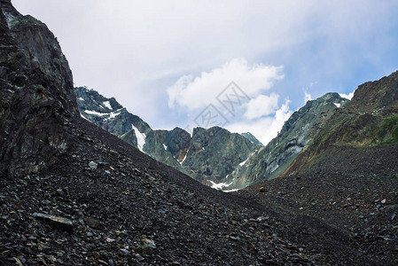 山脉上的雪蓝色多云的天空下的大气雪脊奇妙的巨石爬上高山高地雄伟自然的图片