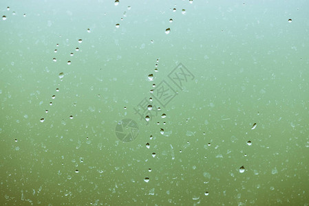 有雨滴的脏玻璃绿色清晰散景背上的雨滴窗外绿意盎然水滴和污渍关闭宏中详背景图片