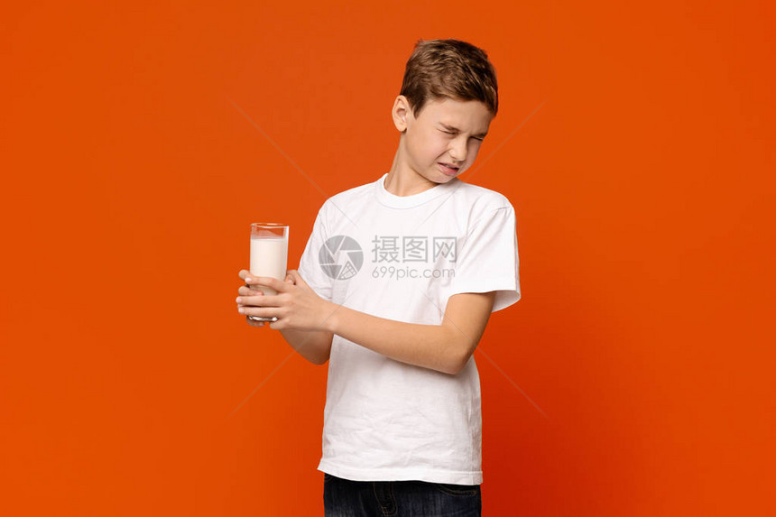 乳糖不容可爱的小男孩不想喝牛奶在橙图片