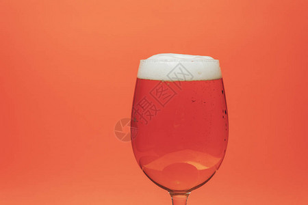 日耳曼珊瑚橙背景上的玻璃啤酒背景