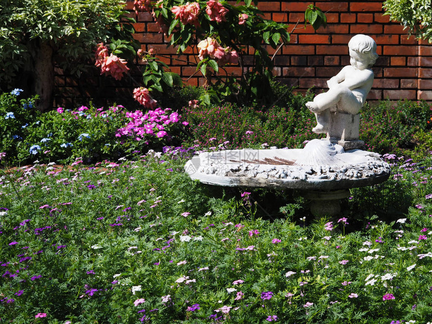 户外花园装饰公园里的旧白色雕塑和鲜花图片