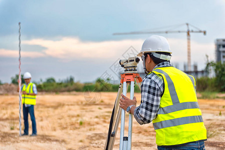 测量员设备测量员在施工现场的望远镜或用于制作等高线计划的测量是启动施工作前土地布背景图片