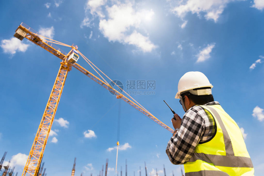 土木工程师在建筑工地或高层建筑工地用对讲机检查工作以进图片