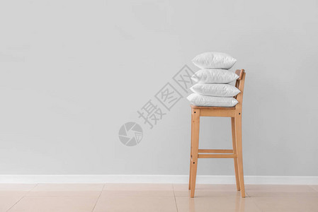 靠在轻墙的椅子上的软枕头背景图片