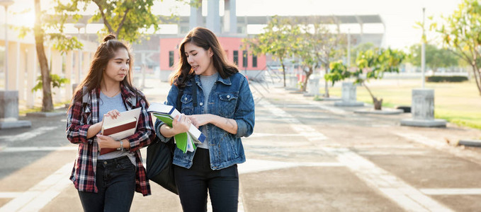两名亚洲女学生在课堂学习后在大学公园讨论课本的最新内容学习和友图片