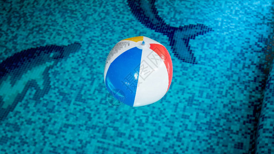 游泳池水面漂浮在游泳池水面的多彩条纹可充气海滩图片