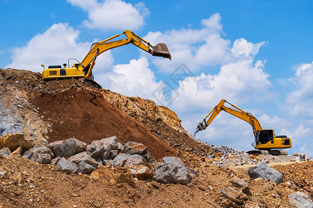 采掘机和碎石粉碎机在蓝色天空下用图片