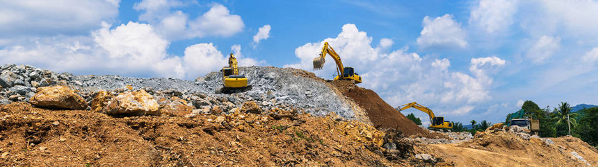 全景挖掘机和碎石粉碎机在蓝色天空下用图片