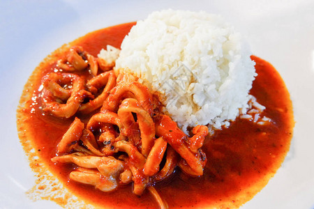 鱿鱼圈在白盘上用熟米饭炒咖喱亚洲食品图片