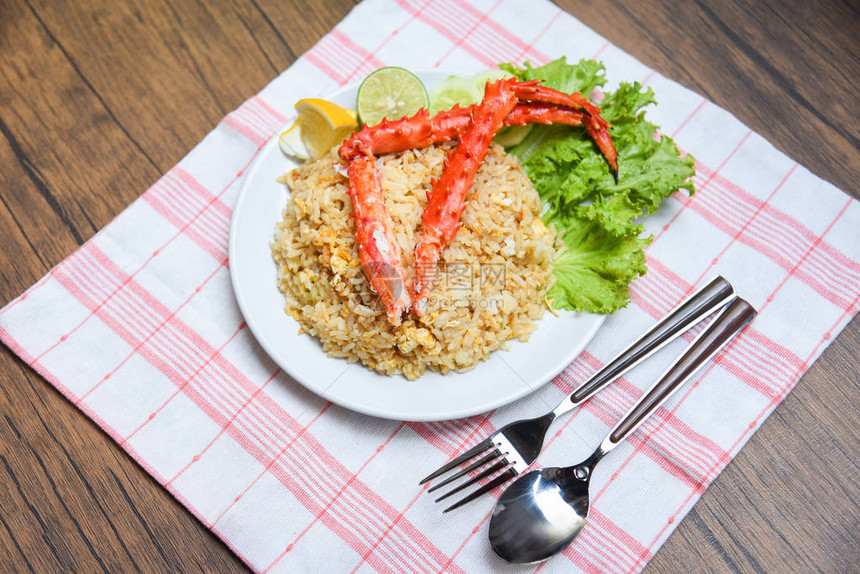 煎饭螃蟹在梨球上吃海鲜健康食品有蟹腿的油炸大米和白板木桌背景的鸡图片