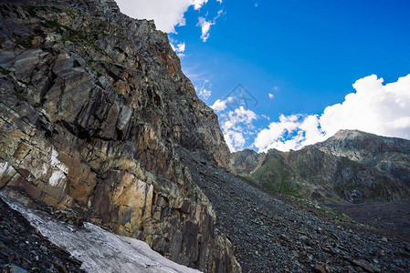 山脉上的雪蓝色多云的天空下的大气雪脊奇妙的巨石爬上高山高地雄伟自然的图片