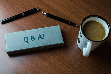 文字书写文本Q和A商业照片展示定义为问题被问和答案上近视图两个圆珠笔盒套装咖啡背景图片