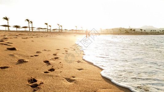 海浪和沙海滨平静的海浪上美丽的日落图片