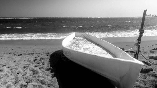 白木老船的美丽形象躺在海边海滩图片