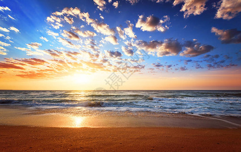 与波浪和多云的日落海滩图片