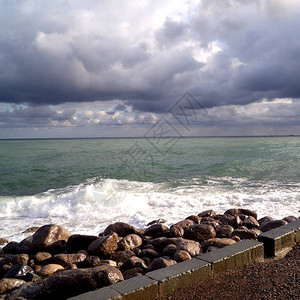 路堤上的石头风暴海景视图灰色的大海上空阴沉的天空海浪和乌云在图片