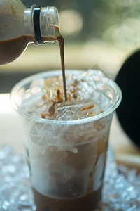 咖啡用冰浇入玻璃为顾客图片