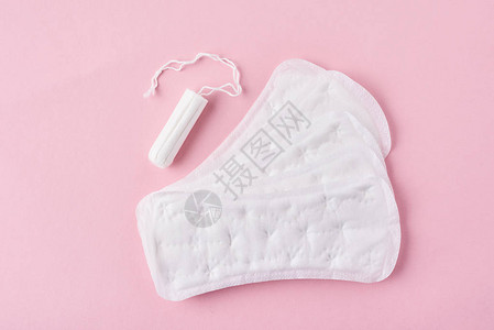 粉红色背景中的卫生巾和月经卫生棉条图片