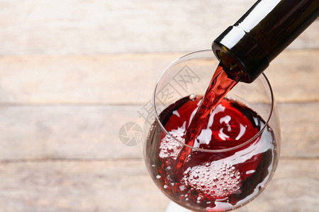 将红酒从瓶装涂到玻璃杯上背图片
