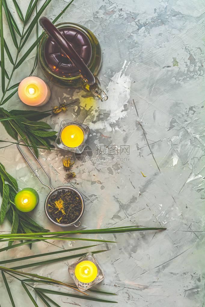 亚洲茶具组成健康生活和放松的概念玻璃茶壶陶瓷壶过滤器中的绿茶和浅灰色混凝土桌背景上的蜡烛顶视图图片