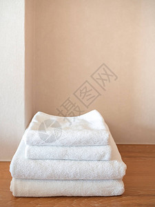 木质表面和白色墙背景上的白色干净毛巾图片