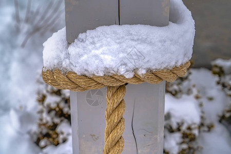 绑在木柱上的绳子上结冰的雪图片