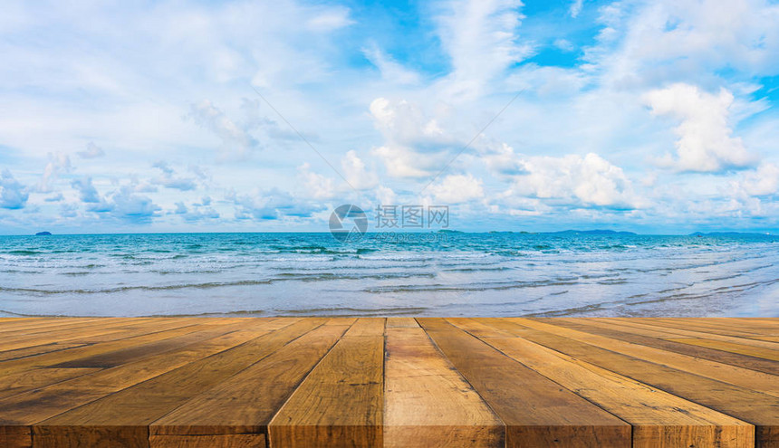 木桌蓝色大海和多云蓝天的图像图片