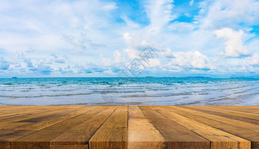木桌蓝色大海和多云蓝天的图像图片
