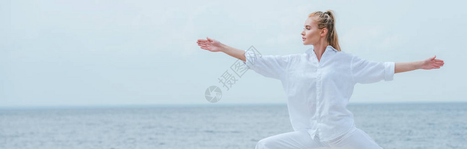 迷人的女孩练习瑜伽和伸出双手站立的全景照片图片