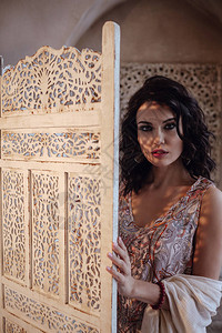 摩洛哥风格的时尚后宫迷人的模特在她马拉喀什的riad度假期间穿着红色连衣裙摆姿势女孩和屏幕背景图片