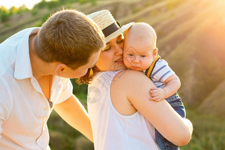 快乐的家庭与小宝一起在日落夏日或秋日温暖的阳图片