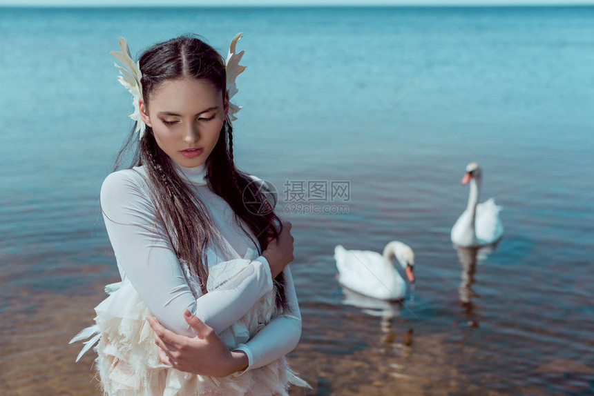 身穿白天鹅服装的年轻女人闭着眼睛与鸟儿图片