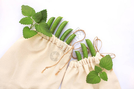 可重复使用的棉袋塑料购物绿豌豆和新鲜蔬菜图片