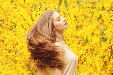 穿黄色鲜花背景的浪漫女人头发图片