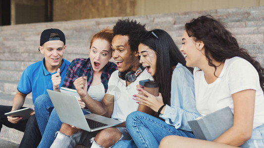 情绪激动的青少年学生在笔记本电脑上兴奋背景图片