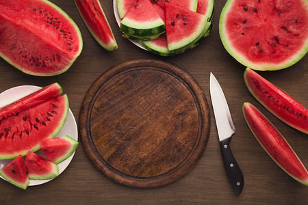夏季食物背景空木板刀子和红熟西瓜切图片