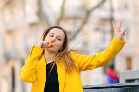 穿黄色大衣的女孩吃黄色的红毛松表图片