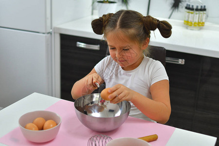 女孩打破了鸡蛋烹饪自制食物用于烹饪面团的鸡蛋天然食品家常菜特写专注图片
